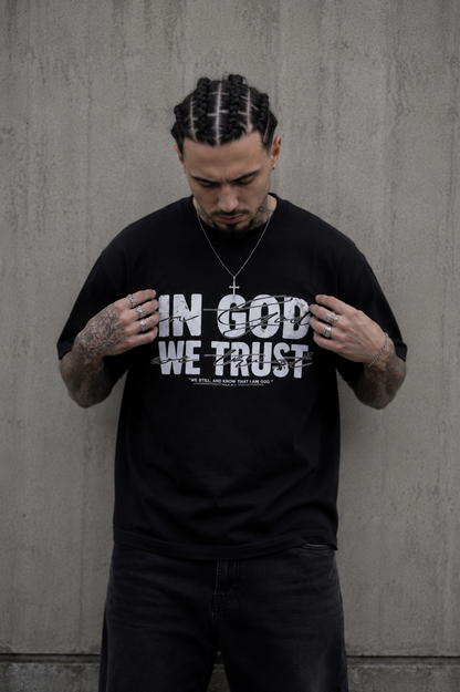 Detailaufnahme des IN GOD WE TRUST Frontprints auf dem schwarzen Oversized T-Shirt von Holyclo.