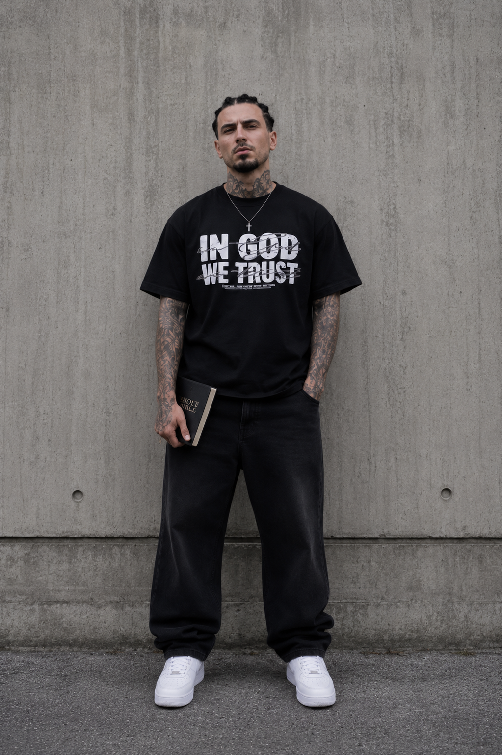 Model trägt schwarzes IN GOD WE TRUST Oversized T-Shirt von Holyclo im modernen Oversized Fit.